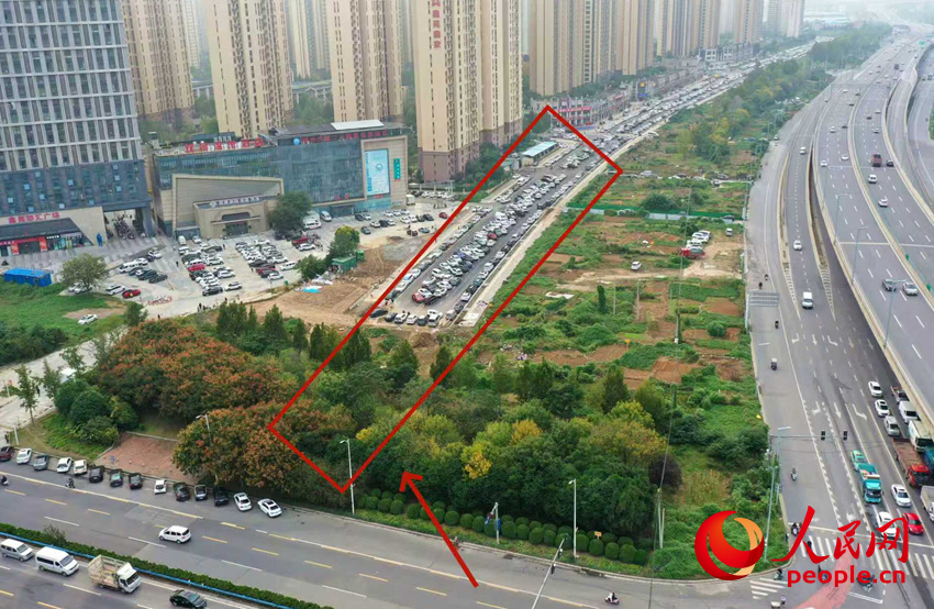 百荣路东段断头，仅剩不到100米就可以与主路连通，路面成了大型停车场。人民网记者 霍亚平摄